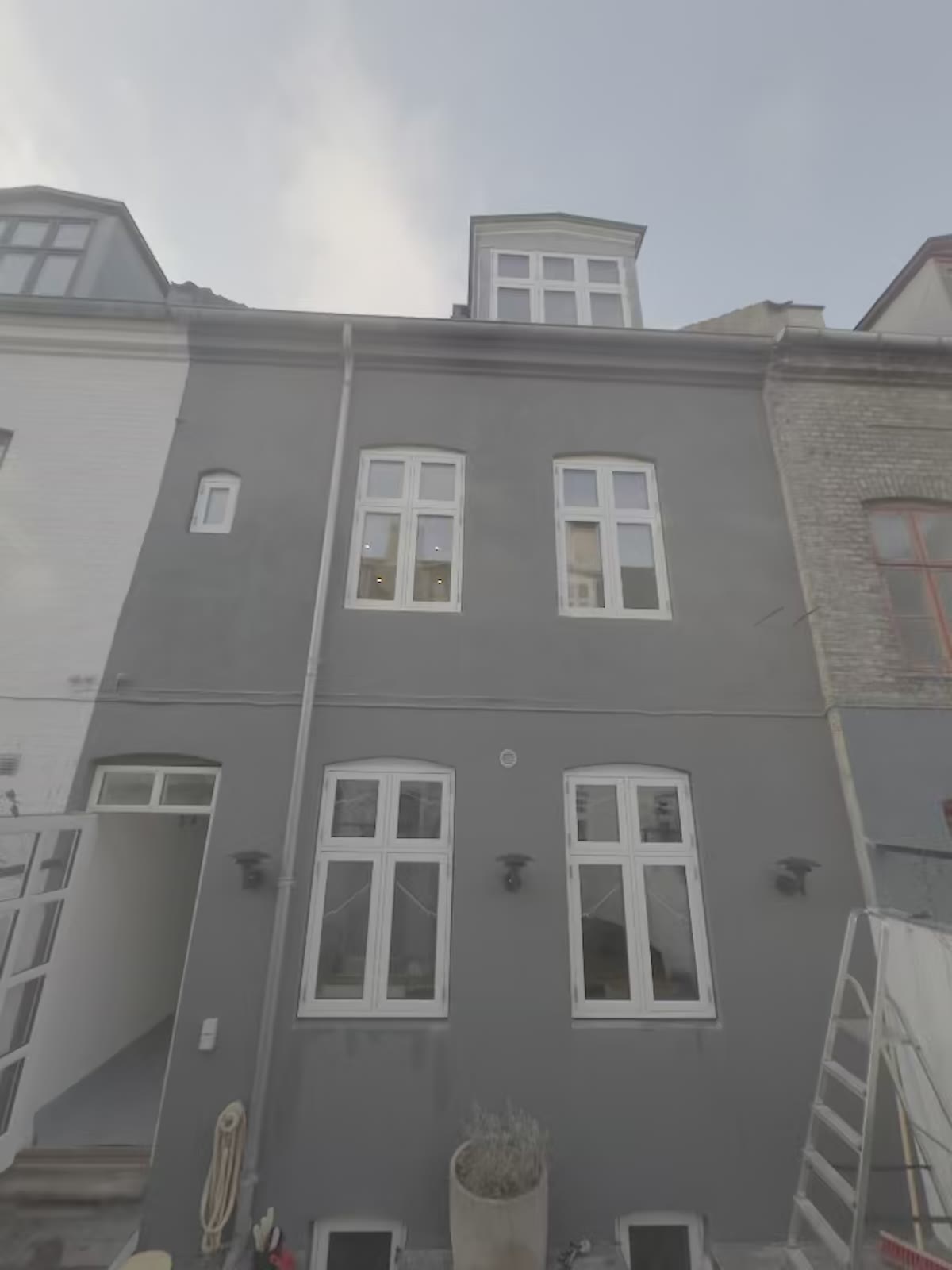 Grå facade med nye hvide vinduer – vinduesudskiftning på ejendommen